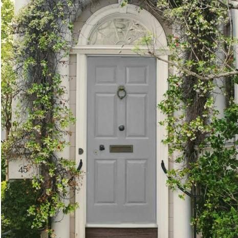 a white front door surrounded by greenery