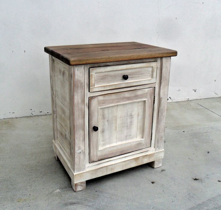 an old white cabinet with wooden top and drawers on concrete flooring next to wall