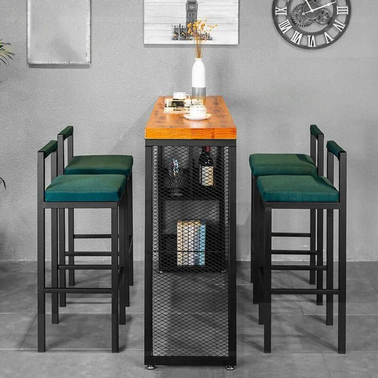 a small table with four stools and a clock on the wall behind it in a room