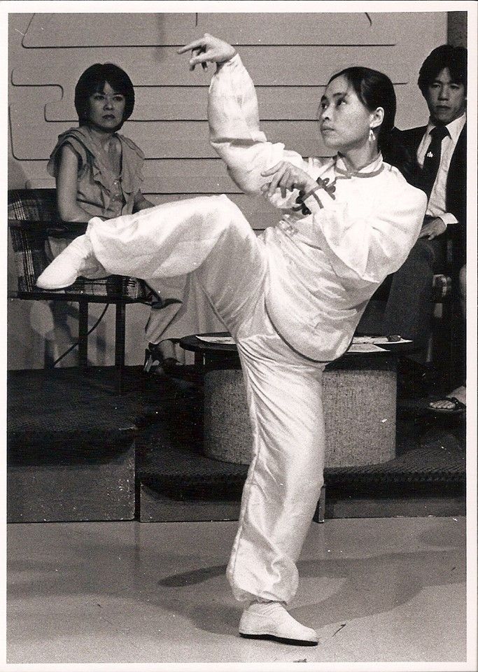 the man is practicing his moves on the dance floor with other people in the background