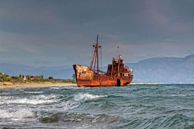 an old rusted ship sitting in the ocean