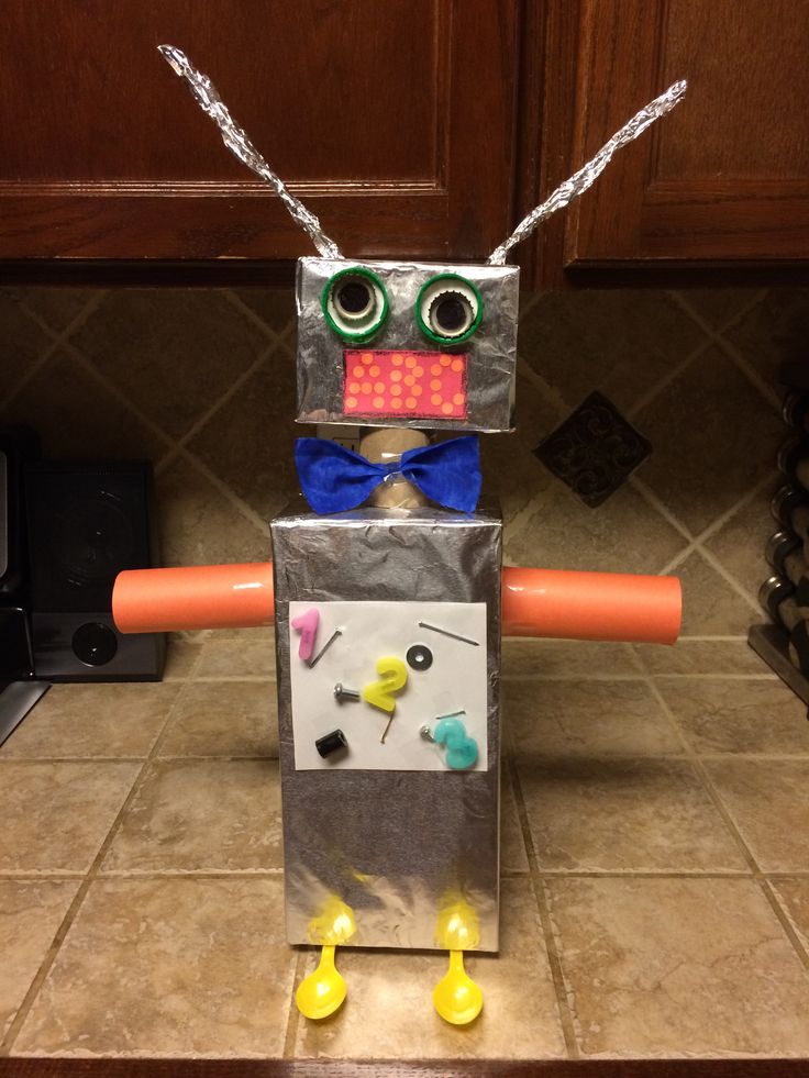 a robot made out of tin foil with eyes and nose sitting on top of a kitchen counter