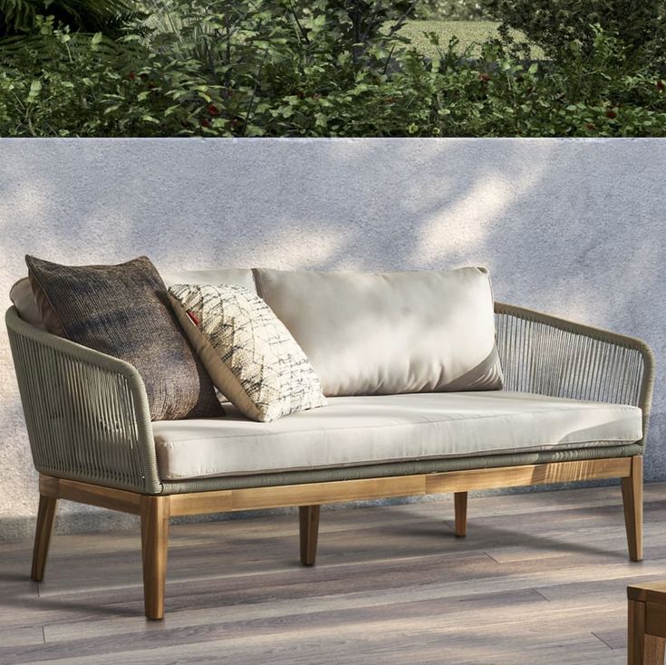 a couch sitting on top of a wooden floor next to a wall with plants in the background