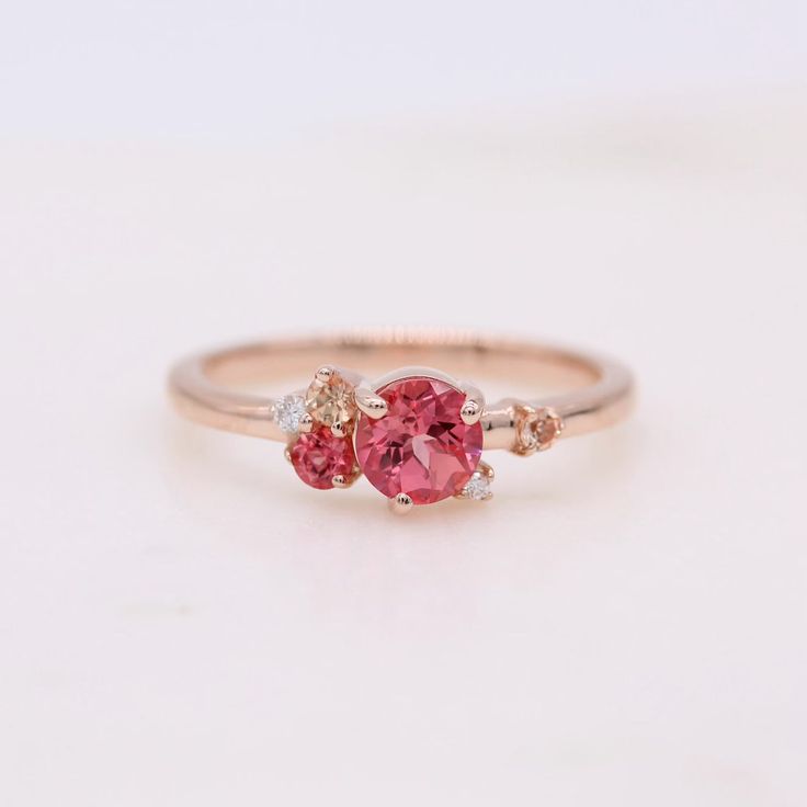 The Padparadscha Sapphire Cluster ring is an expression of pure joy. She gathers created sapphires of varying pink hues and brilliant white lab-created diamonds together into an asymmetrical, sparkling bouquet. At once delicate and intense, this gemstone ring makes the perfect right-hand ring or alternative engagement ring. Details: 14k rose gold 0.66ct padparadscha created sapphire center 0.02ct total weight — lab-grown diamonds 0.81ct total weight — created sapphires *All diamonds are DEF colo Sapphire Cluster Ring, Pink Engagement, Peach Sapphire, Padparadscha Sapphire, Pink Sapphire Ring, Right Hand Rings, Diamond Anniversary Rings, Alternative Engagement Rings, Diamond Anniversary