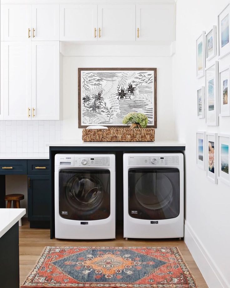 a washer and dryer in a room with pictures on the wall above them