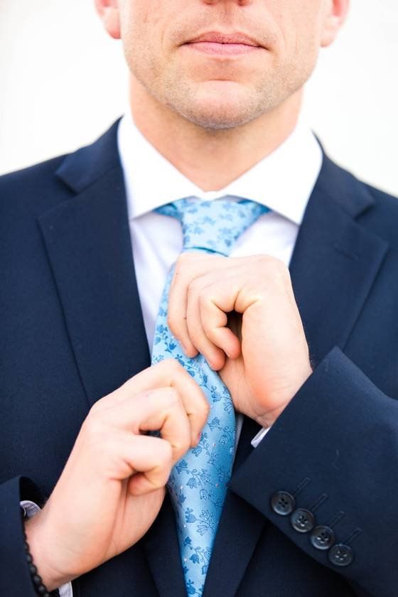 a man in a suit adjusting his tie