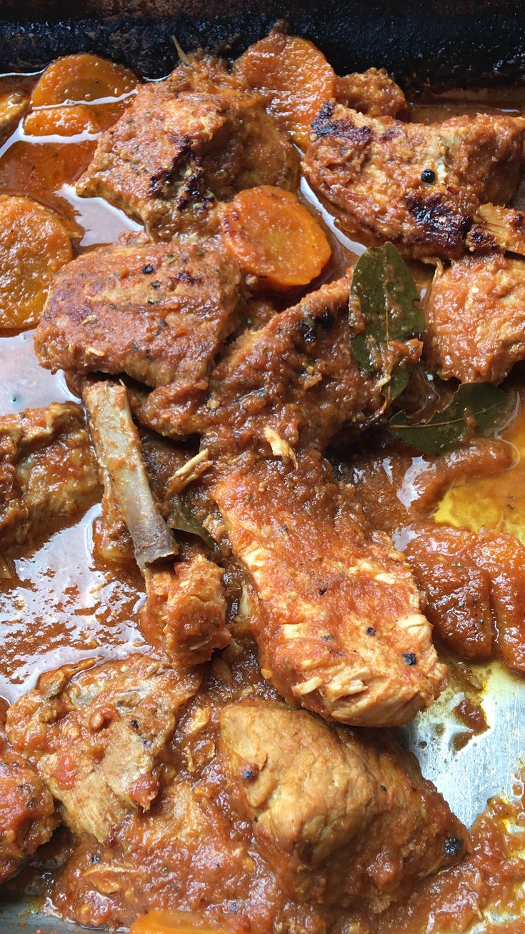 meat and vegetables are being cooked in a skillet