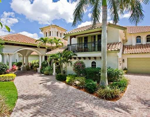 a large house with palm trees and landscaping