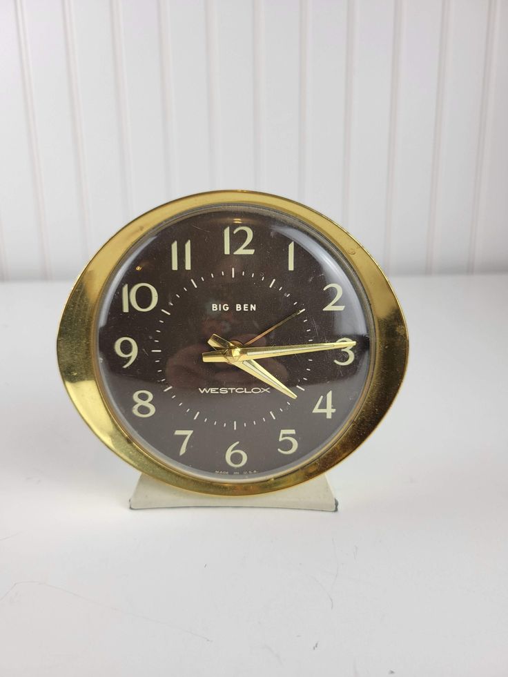 a small clock sitting on top of a white table