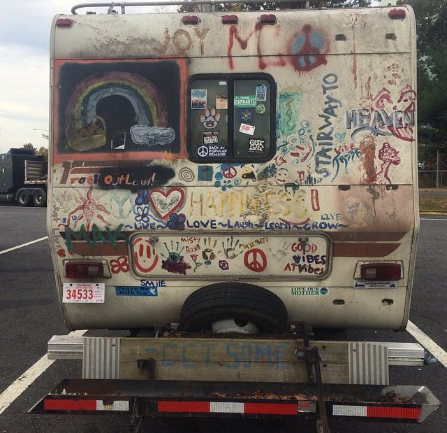 the back end of an old van with graffiti on it's sides and windows