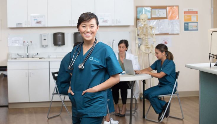 a woman in scrubs standing next to a table