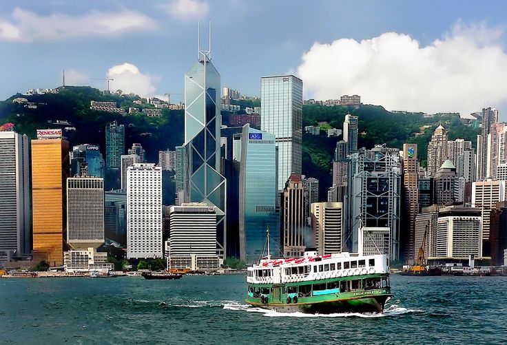 a large boat is in the water near some tall buildings