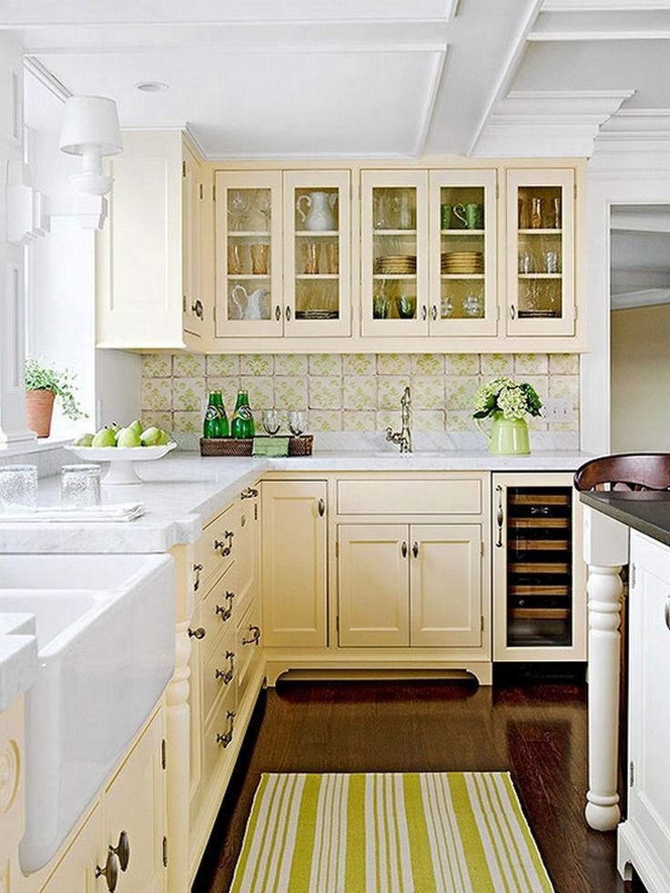 a kitchen filled with lots of white cabinets and counter top space next to a sink