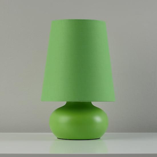 a green lamp sitting on top of a white table