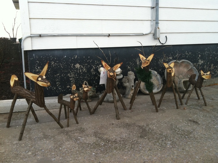 several metal deer sculptures sitting on top of a sidewalk next to a garage door,