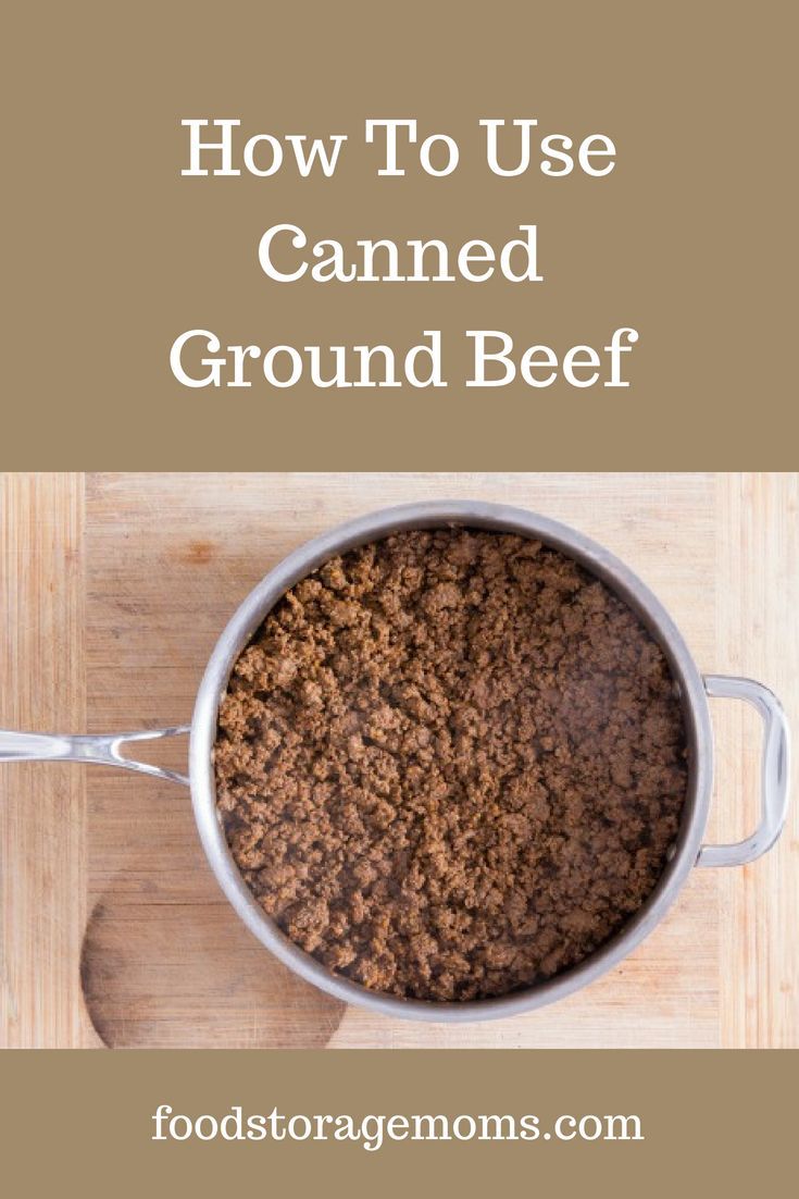 a pot filled with ground beef on top of a wooden table