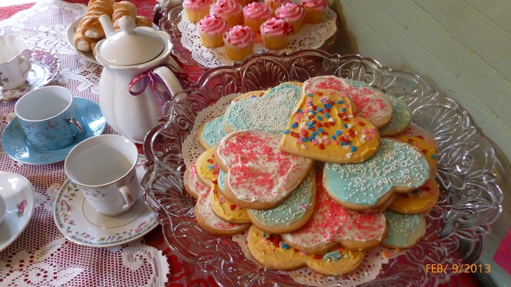 a table topped with lots of different types of cookies and cupcakes on top of glass plates