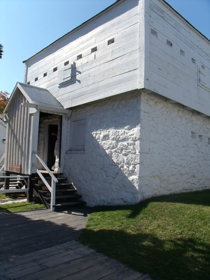 an old white building with stairs leading up to it