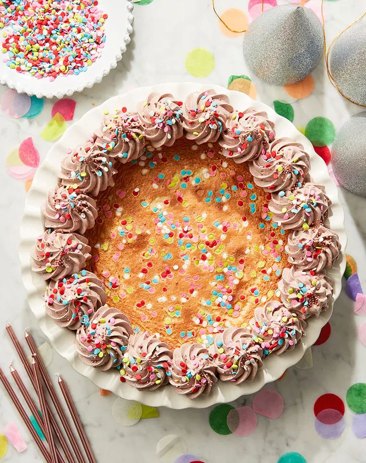 a birthday cake with sprinkles and chocolate frosting in a pie pan