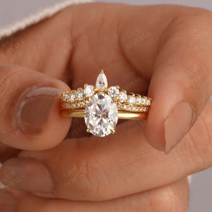 a woman's hand holding an engagement ring with two diamonds on the top and bottom