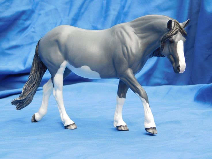 a toy horse is standing on a blue background