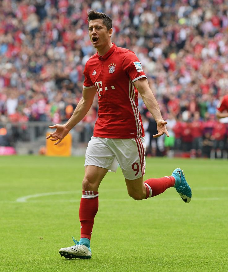 a soccer player is running on the field with his mouth wide open and tongue out