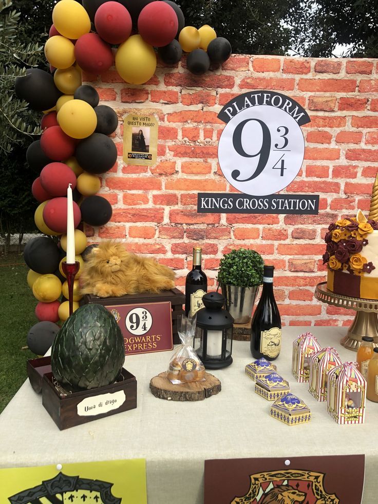 a table topped with lots of different types of cakes and desserts next to a brick wall