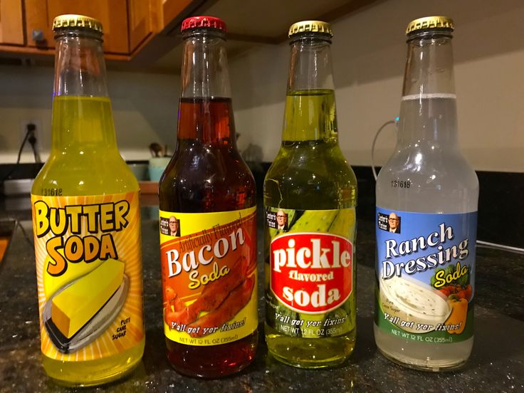 four bottles of soda sitting on top of a counter