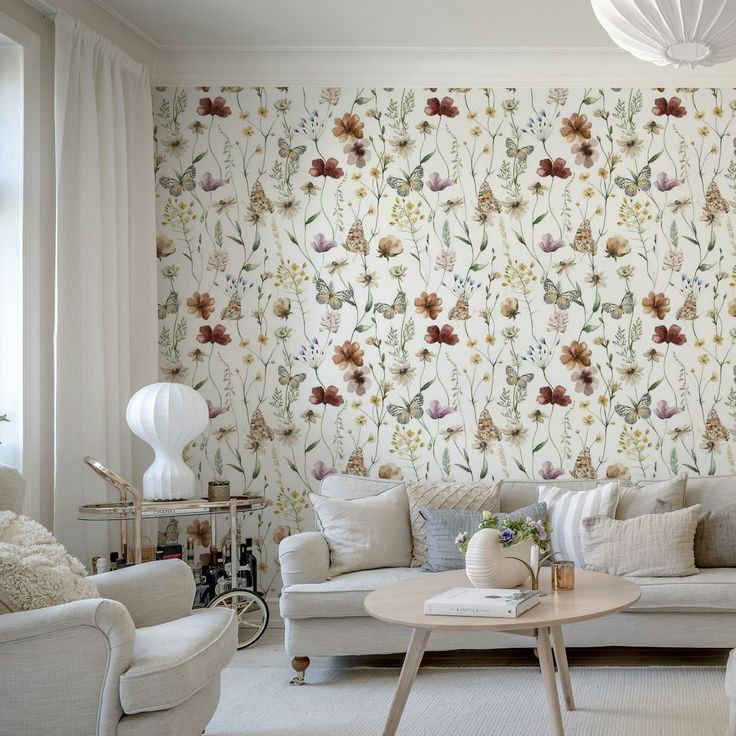 a living room with floral wallpaper and white furniture