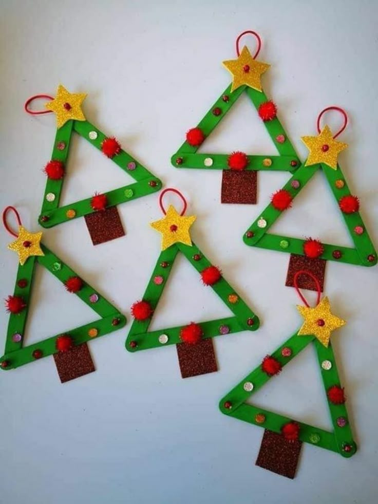 christmas tree ornaments made out of popsicle sticks and colored felt are arranged in the shape of trees