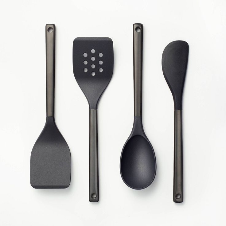 three black utensils and spoons on a white surface