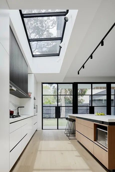 an image of a kitchen with skylights in the ceiling and windows on the wall