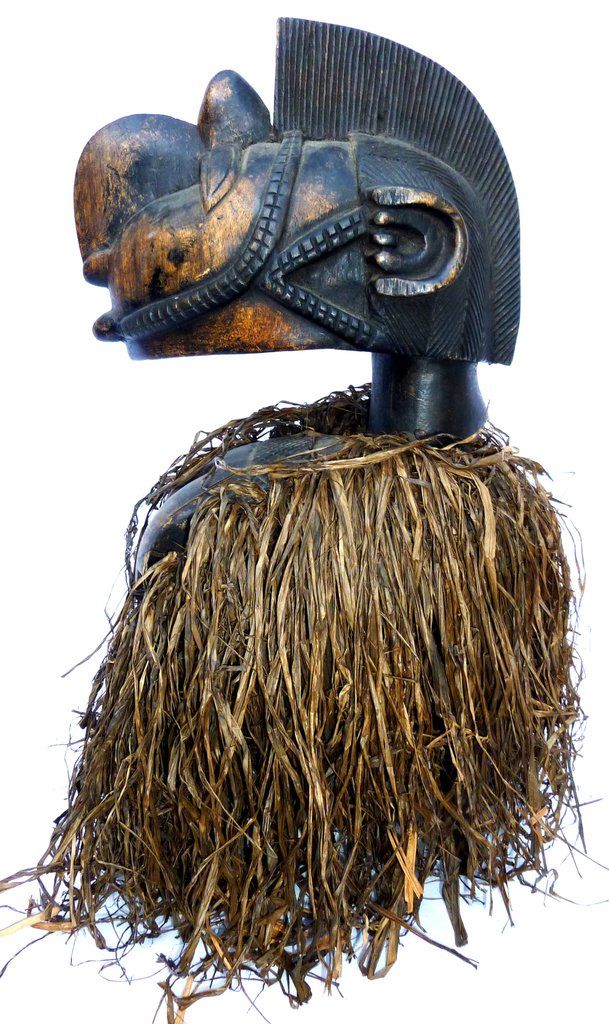 an african mask with grass on it's head is shown against a white background