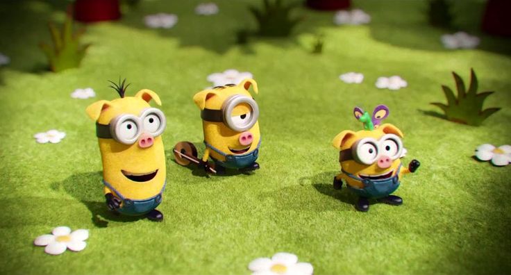 three minion characters are sitting in the grass