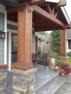 an outdoor covered porch with stone steps and seating area on the side of the house