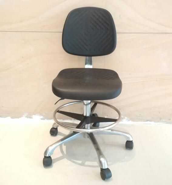 a black office chair sitting on top of a white floor in front of a wall