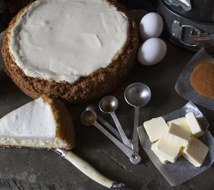 a cake with white frosting on top next to other baking utensils and ingredients