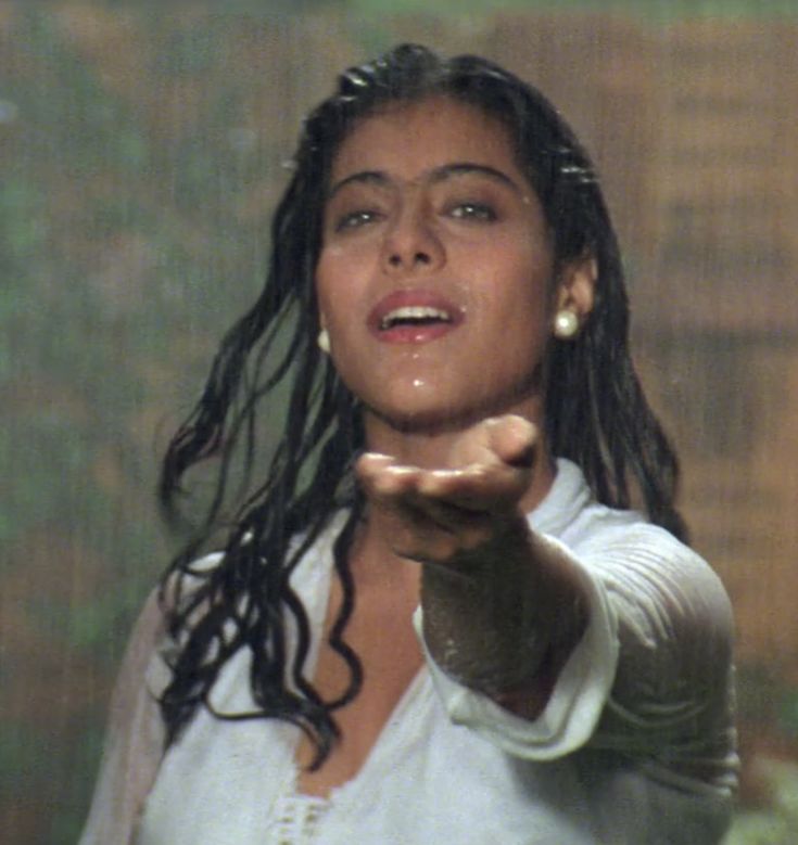 a woman is holding her hand out in the rain