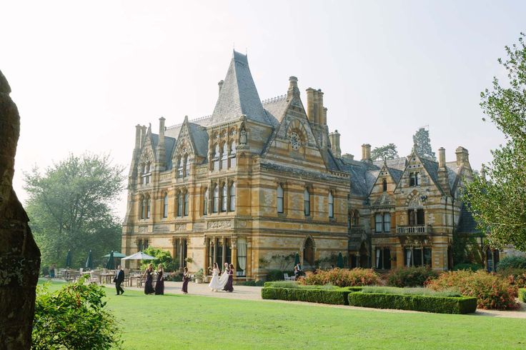 a large building with many windows and people walking around the yard in front of it