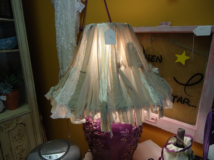 a lamp shade sitting on top of a table next to a cake and other items