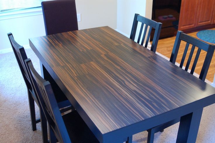 a wooden table with chairs around it in a room