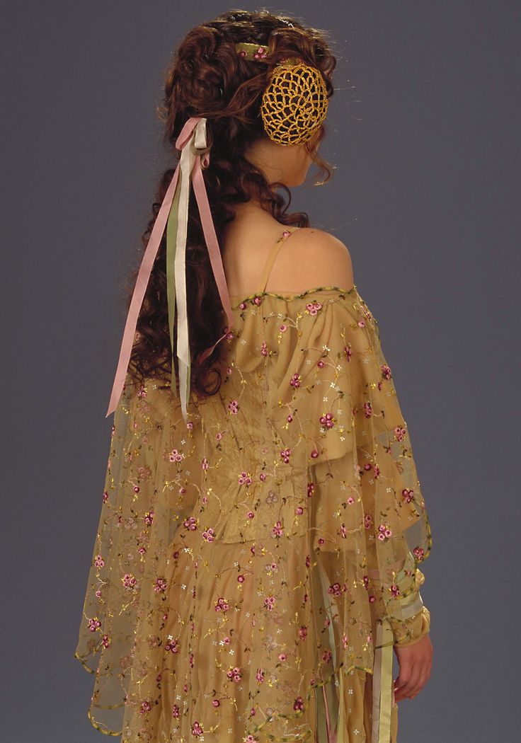 a woman in a yellow dress with pink flowers on it's head and hair