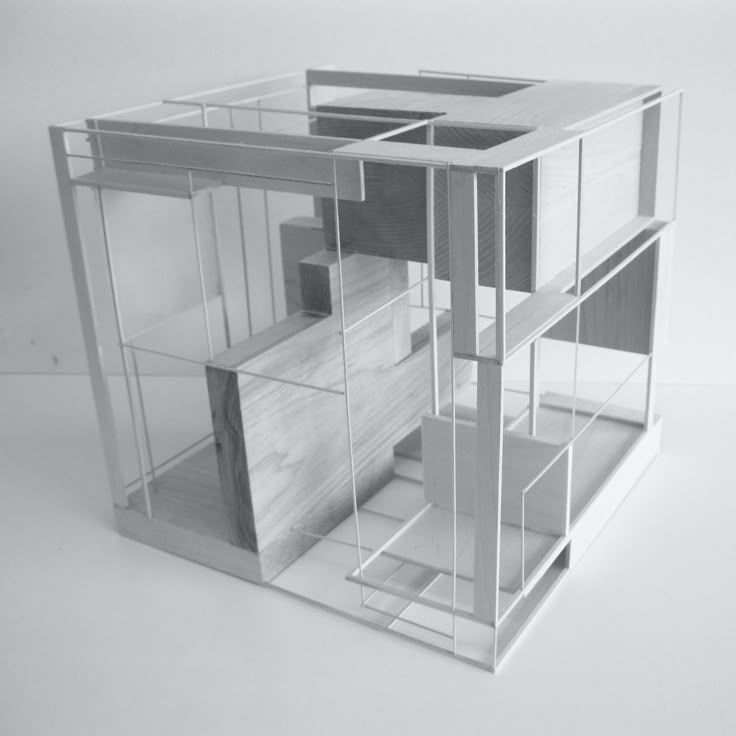 an architectural model of a house made out of wood and glass, on a white surface