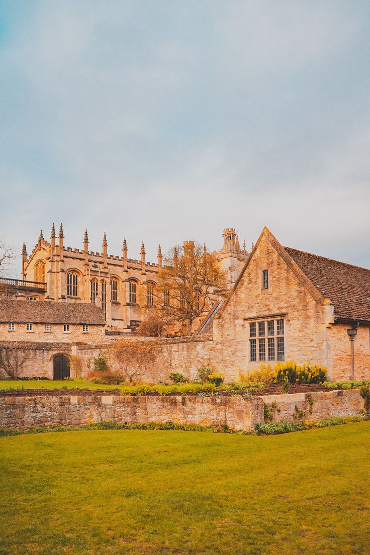 an old stone building in the middle of a green field