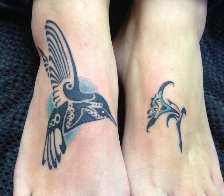 two feet with tattoos on them and one has a bird