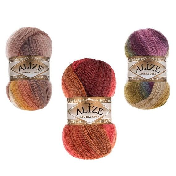 three skeins of alze yarn in different colors and sizes on a white background