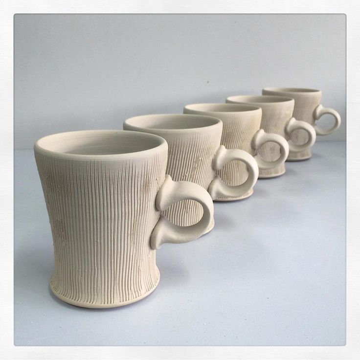 five white coffee cups lined up in a row