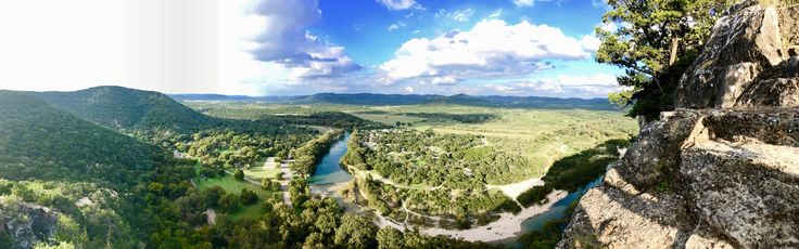 a panoramic view of the valley and river from high up in the mountains