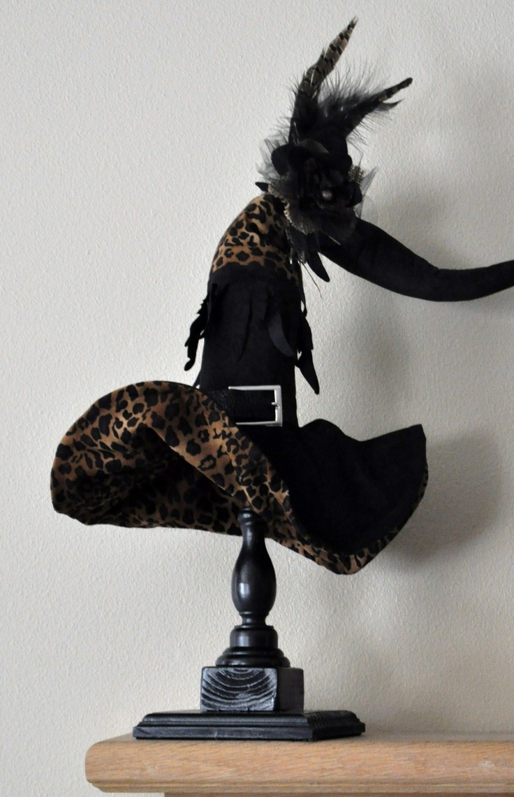 a black and leopard print dress sitting on top of a wooden table next to a clock