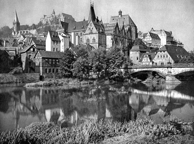 an old black and white photo of a city with buildings on the other side of it